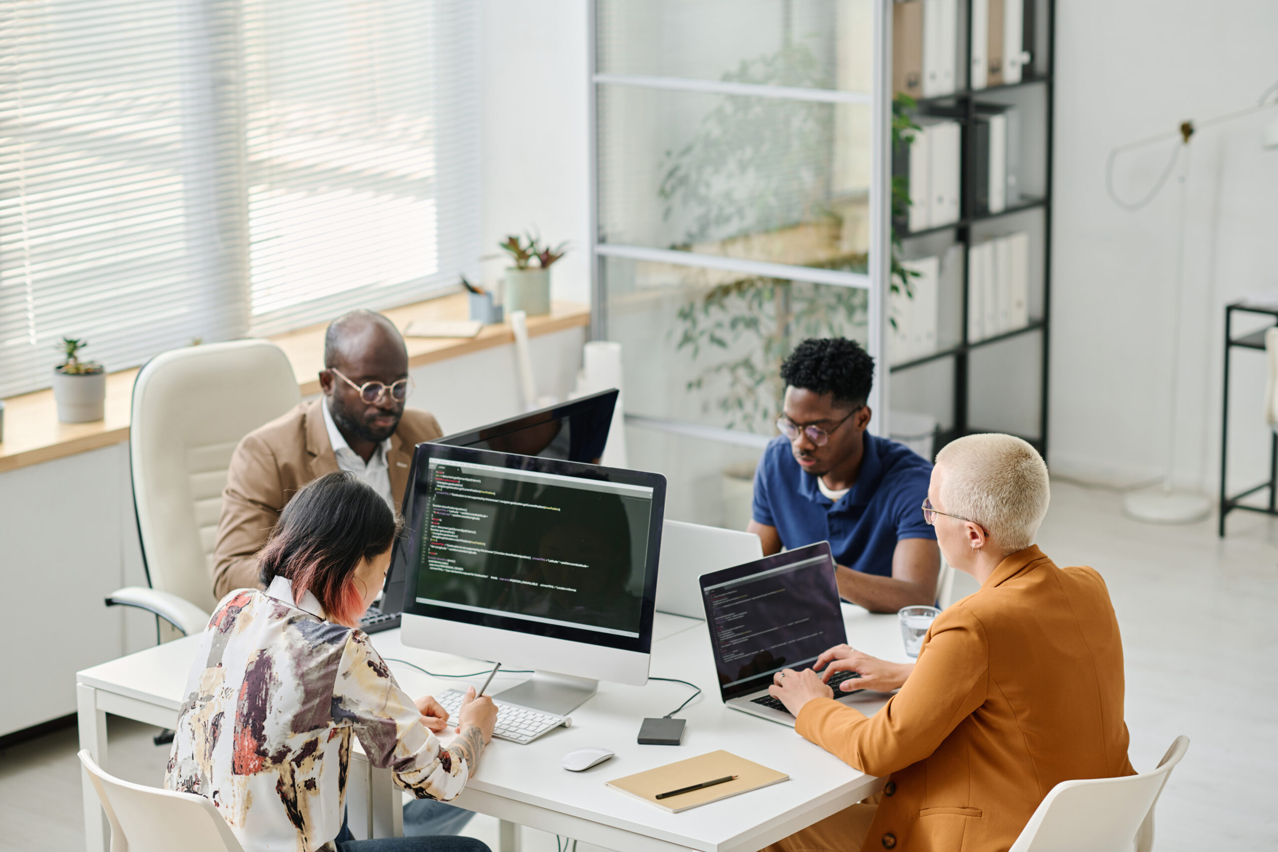 A group of IT professionals collaborating on DevOps projects in a modern office environment, focusing on cloud computing and software development.
